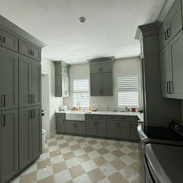 Modern laundry room with gray cabinets and checkered tile floor.