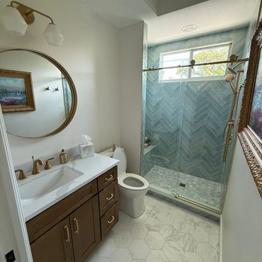 Modern bathroom with hexagonal tiles and glass shower enclosure.