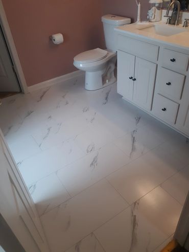 Modern bathroom with white marble floor tiles and a white vanity.