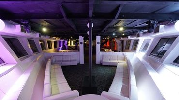 View of long white couches on lower deck of Harbor Lights yacht