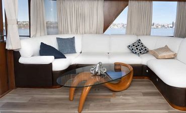 Interior of yacht, white couches and coffee table