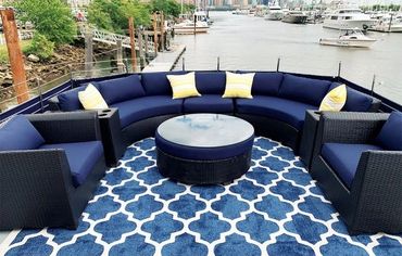 Aft deck of Juliette, navy couches shaped in similar cirle with coffee table
