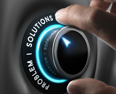 A hand turning a dial from problem to solution mode.