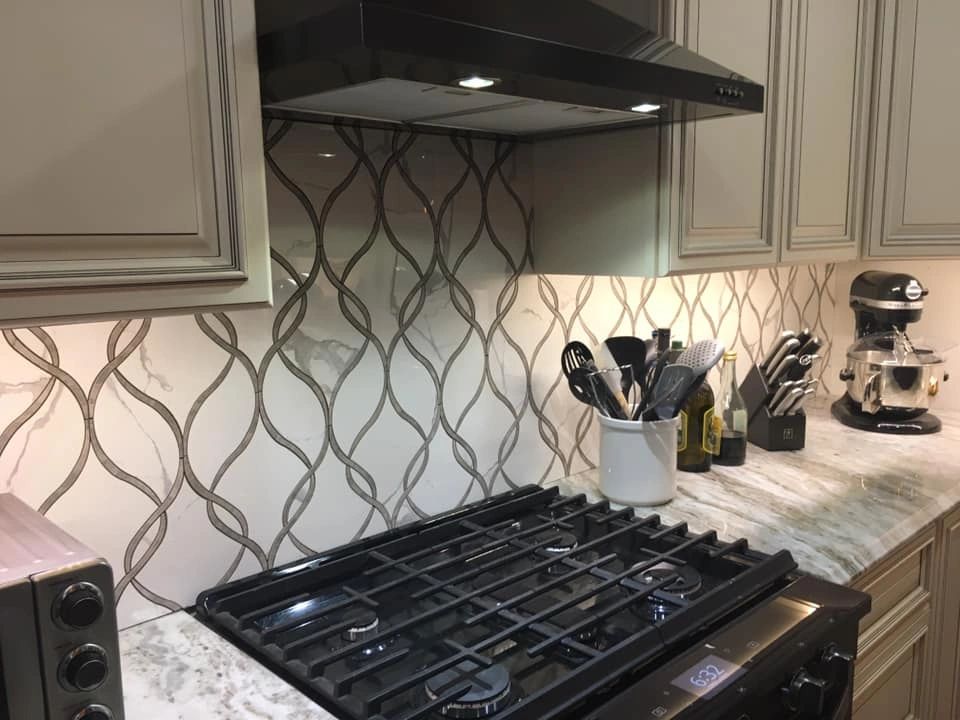 A well-appointed kitchen cooking area featuring granite countertops and cream-colored cabinets.