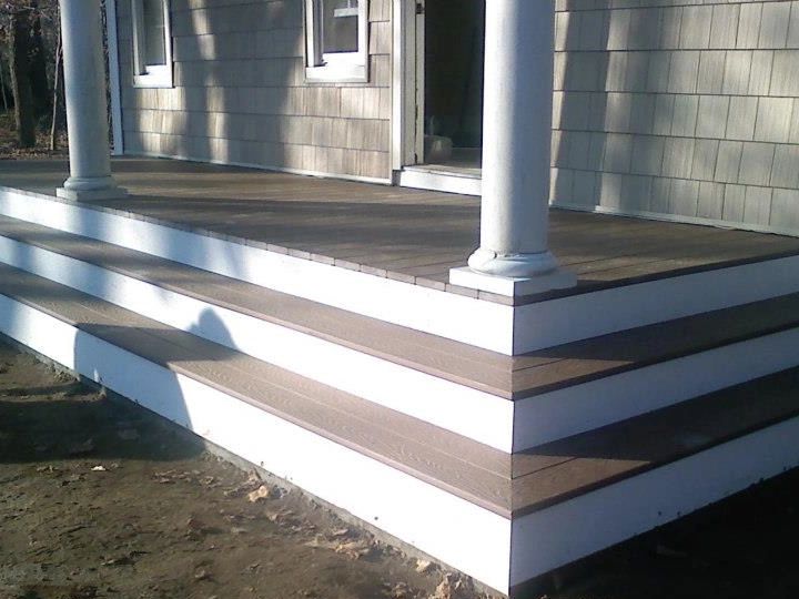 Rebuilt deck on a 120-year-old home featuring wide composite steps with white risers and trim.