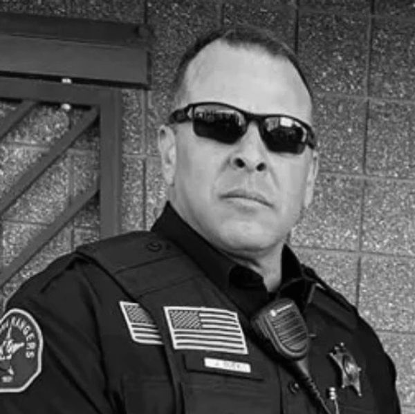 Police officer in uniform with sunglasses and radio.