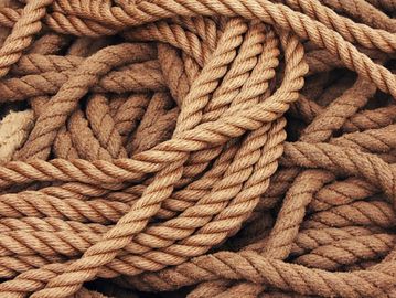 A close-up of coiled natural fiber ropes tangled together.