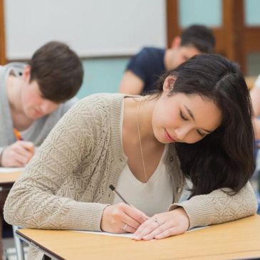 Students focused on writing during an exam in a classroom.