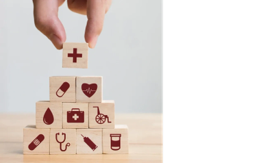 Hand stacking wooden blocks with healthcare icons.