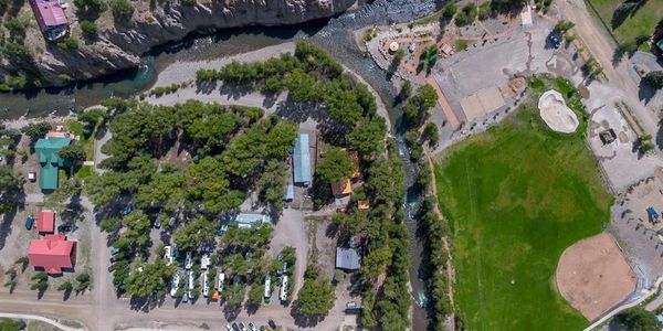 Aerial view of a green park with boats, trees, and a baseball field.