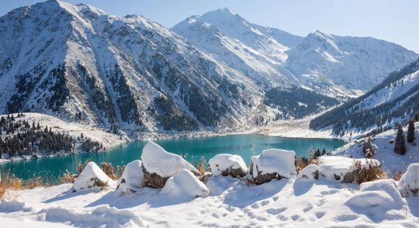 Snow-covered mountains surrounding a turquoise lake.