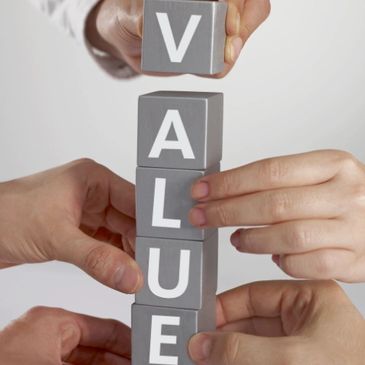 Photo realistic image of three sets of hands stacking blocks that spells the word Value.
