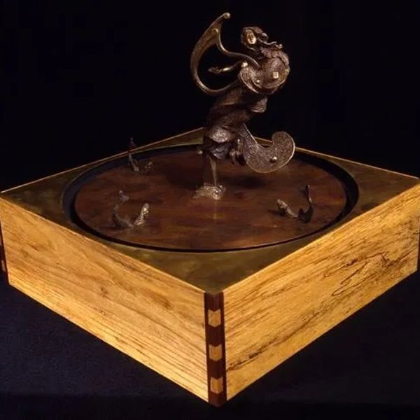 Intricate bronze sculpture on a wooden base.