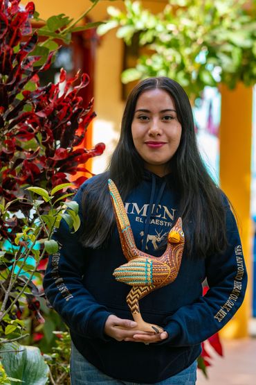 Ana Vásquez, con una obra decorada a mano en simbología zapoteca.