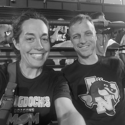 Mary and David Allen wearing Nacogdoches Dragons shirts at a community football game.