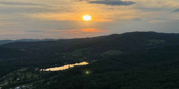 Sunset Hot Air Ballloon Ride!  View of the mountains with a reflection off of a body of water.