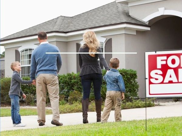 Family of four looking at a house for sale.