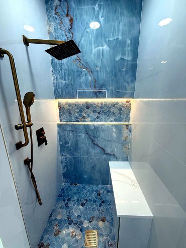 Luxury blue marble shower with brass fixtures.