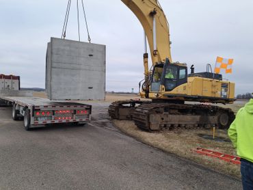 W.M. Davis Infrastructure excavator setting a precast concrete sanitary sewer structure on an Ohio i