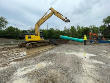 W.M. Davis Infrastructure crew installing large-diameter underground utility pipe using company-oper