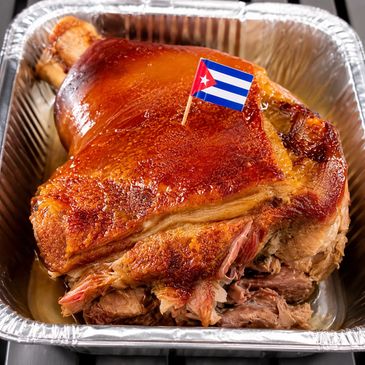 Cuban-style roasted pork with crispy skin in a tray.