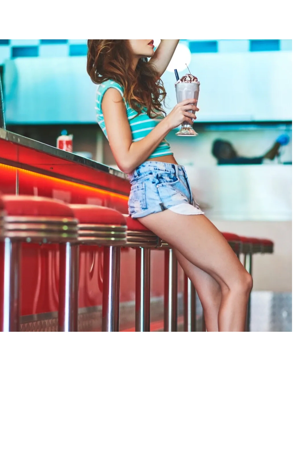 retro diner - girl sitting on chrome stool at vintage diner with milkshake - perfect travel outfits