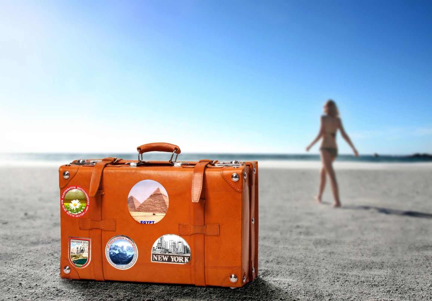 suitcase on the beach - suitcase filled with vintage clothing - vintage suitcase with stickers