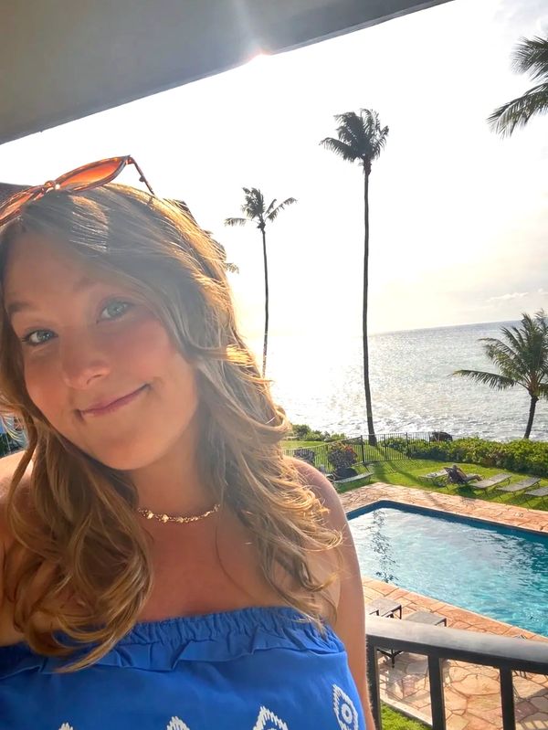 Woman smiling at oceanfront resort.