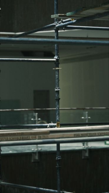 Close-up of scaffolding pipes and wooden planks.