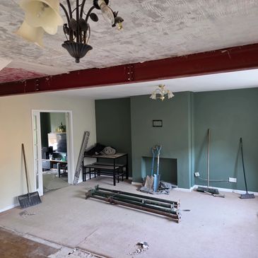 Room under renovation with tools and exposed wall section.