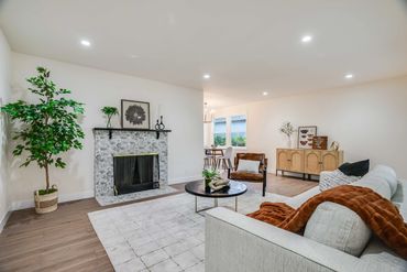 Modern living room with fireplace, leather chair, and cozy couch.