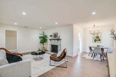 Bright, modern living room with fireplace and dining area.