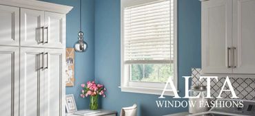 Modern kitchen with white cabinets and blue walls featuring Alta Window Fashion blinds.