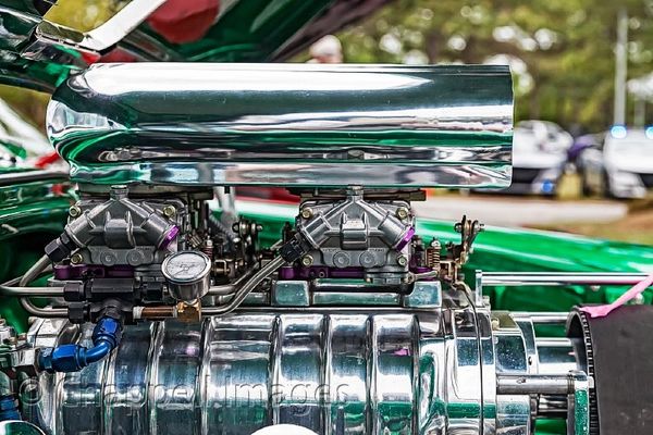 Chrome Super Charger under hood of green car