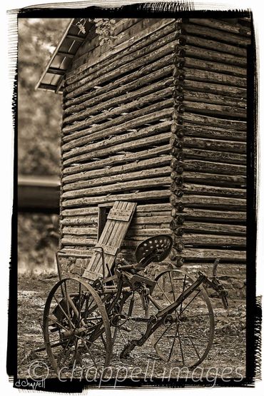 Old plow stands in rot of old tobacco barn