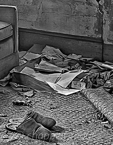 Shabby slippers sit on dirty rug. A Note that just says "Mom" is seen is the rubble.