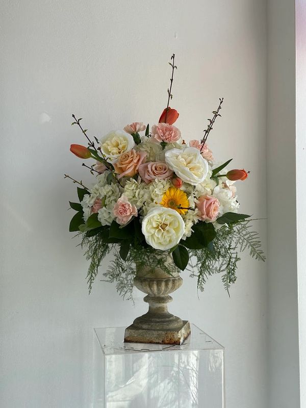 Elegant mixed flower arrangement in a stone vase.