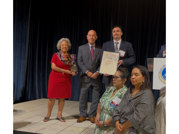 Group receiving awards on stage during a formal event.