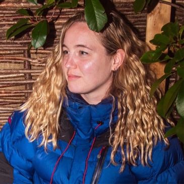 Woman with blonde hair wearing a blue jacket.