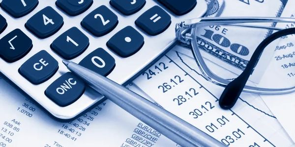Calculator, pen, glasses, and financial documents with money.