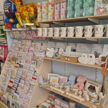 Gift shop shelves with mugs, cards, and decorative items.