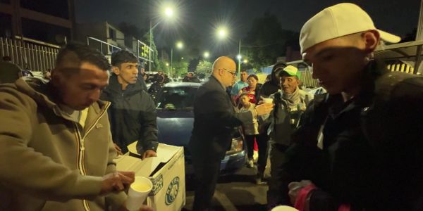 Personas distribuyendo comida en la noche.