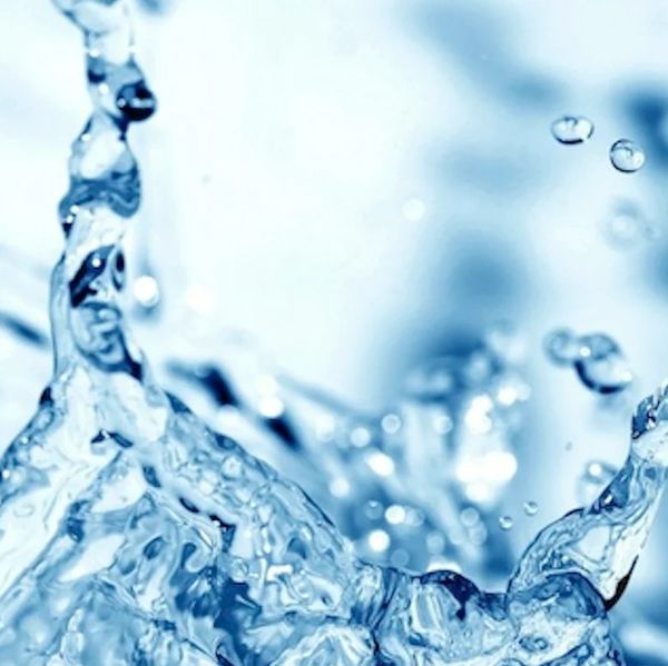 Close-up of clear water splashing with droplets suspended mid-air.