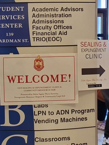 Signboard listing student services and a Sealing & Expungement Clinic.