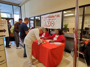 People signing up at a Delta Sigma Theta Sorority booth.