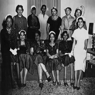 Historic black-and-white photo of a group of women in formal attire.