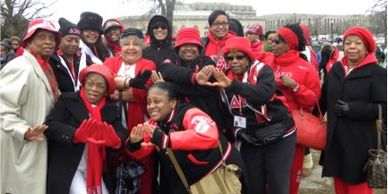 Group of smiling women in red and black outdoor attire.