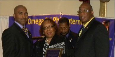 Four people at an award ceremony with a plaque.