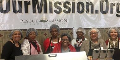 Volunteers at a rescue mission serving food.