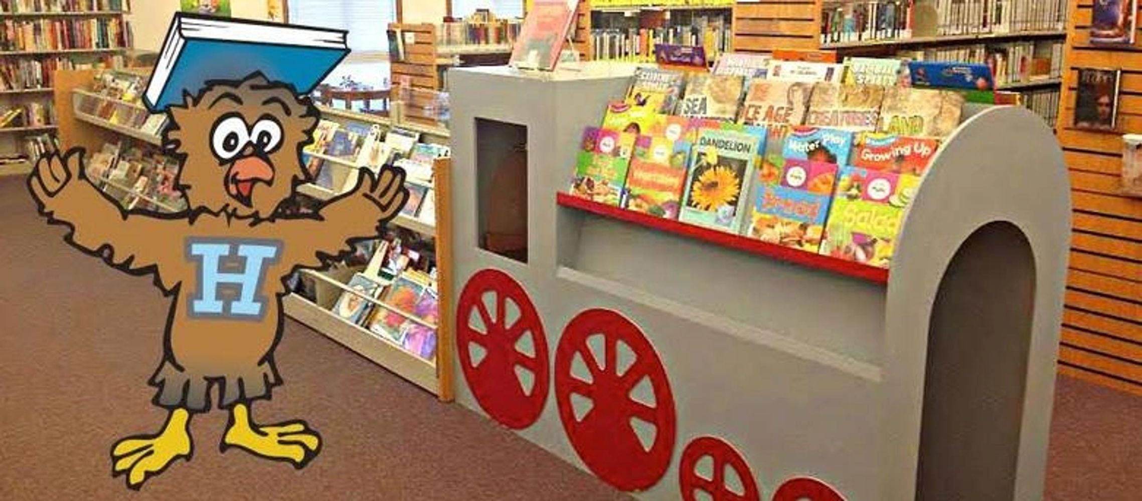 Homer the Library Owl showing off our Children's Browser Bins with easy picture books.